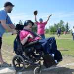 Photo by Rashah McChensey/Peninsula Clarion Isaac Cryer helps Chuck Davis, both of Soldotna, round third base during the annual World Series of Baseball event for community members with developmental disabilities on Friday June 19, 2015 in Soldotna, Alaska.