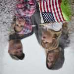 Photo by Rashah McChesney/Peninsula Clarion  Kenai City Manager Rick Koch smokes a cigar while driving a '73 Mustang with the Kaknu Kruzers car club during the annual Independence Day parade on Saturday July 4, 2015 in Kenai, Alaska.