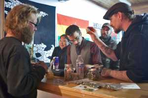 Maureen Hensley, of Kenai, uses her spare time to paint a mural on the windows of Green Rush Events Clubhouse on Saturday in Kenai. Photo by Megan Pacer/Peninsula Clarion