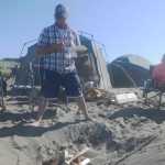 Ben Boettger/Peninsula Clarion Dipnetters John Collins (left), Jeremy Coulson (center,) and Chelsee Largo (right) eat a brunch of bacon and eggs at their encampment on Kenai's north beach on Sunday, July 19.