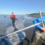 Ben Boettger/Peninsula Clarion Jill Brown (foreground) hauls in a fish while John Collins (background) returns to the water of Kenai's north beach on Sunday, July 19.