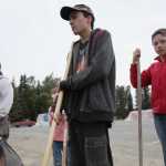 Ben Boettger/Peninsula Clarion Eagle Scout candidate Brett Brown (left) directs (left to right) Melody Cox, Max Cox, and Joey Freeman in smoothing a dirt patch for a beautification project between Kenai Central High School and Lawton Drive on Tuesday, July 21.