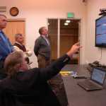 Photo by Megan Pacer/Peninsula Clarion Alaska Department of Revenue Commissioner Randall Hoffbeck demonstrates a revenue expenditure model, created to give Alaskans the chance to get involved in discussions on state sustainability, for Nikiski resident Wayne Ogle (left), Kenai City Council Member Tim Navarre (center), and Kenai Peninsula Economic Development District Executive Director Rick Roeske (right) on Tuesday afternoon in the Kenai Community Library in Kenai, Alaska.