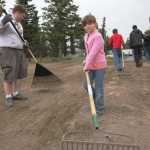Ben Boettger/Peninsula Clarion During a beautification project led by Eagle Scout candidate Brett Brown (left), volunteer Melody Cox (right) rakes a patch of dirt between Kenai Central High School and Lawton Drive on Tuesday, July 21.