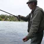 Ben Boettger/Peninsula Clarion Art Baker twitches his hook at the end of a drift by pulling out the line with his hand on the bank of the Kenai, behind the Kenai River Center in Soldotna, on Tuesday, July 21.