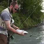 Ben Boettger/Peninsula Clarion Jimmy Mueller holds a salmon caught on the Kenai River in Soldotna on Tuesday, July 21. The salmon was snagged; Mueller released it.