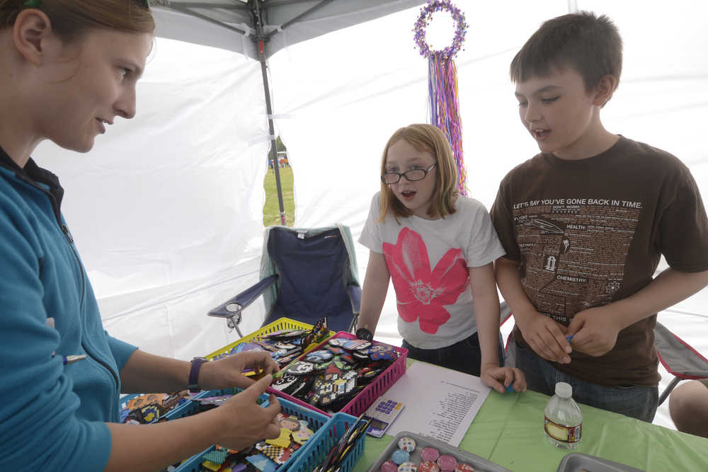 Megan Pacer/Peninsula Clarion Chainsaw scultpor Eric Benson, owner of the Dreamer's Wood chainsaw sculpting business in Sterling, carves a bear during the Sawfest Chainsaw Carving Competition in Centennial Park on Friday, July 25.