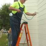 Photo by Megan Pacer/Peninsula Clarion Sam White, of West Virginia, sprays a fresh coat of paint onto the Holy Assumption of the Virgin Mary Russian Orthodox Church Tuesday morning in Old Town Kenai.