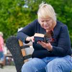 Photo by Rashah McChesney/Peninsula Clarion  Griselda Mustard, of Soldotna, reads Richard North Patterson's "Protect and Defend" on a sunny day Thursday July 30, 2015 at Soldotna Creek Park.