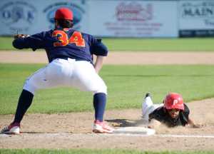 Photo by Kelly Sullivan/ Peninsula Clarion Kenai Peninsula Oilers Brian Ruhm slides back into first base Thursday, July 30, 2015, at Coral Seymour Park in Kenai, Alaska.