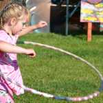 Photo by Megan Pacer/Peninsula Clarion Hayley Herman, 7, plays with a hoola hoop in front of Salmonfest's main stage on Friday July 31, 2015 in Ninilchik, Alaska.