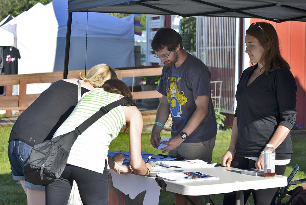 Photo by Megan Pacer/Peninsula Clarion Bryan Goldstein (left) and Alexandra Guilford (right) share their message about proposed mines in British Columbia that would threaten Alaska's salmon rivers with pasersby on Friday July 31, 2015 in Ninilchik, Alaska.