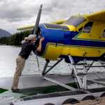 In this Wednesday, July 22, 2015 photo, Sean Kveum does a preflight check on a hydroplane in Juneau, Alaska. The homegrown pilot is now the safety director at Alaska Seaplanes where he has a hand in training new pilots and developing emergency response plans. With more than 250 villages statewide lacking road systems, it's the daily trips to the grocery store and doctor visits that keep Kveum busy. (Michael Penn/Juneau Empire via AP)