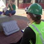 Photo by Megan Pacer/Peninsula Clarion K.J. Hillgren (right) questions 5-year-old Lyman Winger (left) about his fake injuries during an earthquake simulation on Saturday Aug. 8, 2015, at Soldotna Prep School in Soldotna, Alaska. The simulation was the last hurdle for members of this summer's Community Emergency Response Team course.
