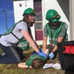 Photo by Megan Pacer/Peninsula Clarion Community Emergency Response Team course members Melissa Daugherty (left) and Jeremiah Millette (right) treat 5-year-old Lyman Winger for fake injuries during a simulated earthquake exercise held Saturday Aug. 8, 2015, at Soldotna Prep School in Soldotna, Alaska.