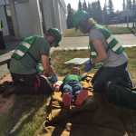 Photo by Megan Pacer/Peninsula Clarion Community Emergency Response Team course members Jeremiah Millette (left) and Melissa Daugherty (right) treat 5-year-old Lyman Winger for fake injuries during a simulated earthquake exercise held Saturday Aug. 8, 2015, at Soldotna Prep School in Soldotna, Alaska.
