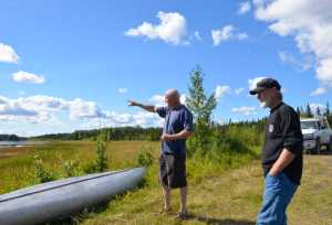 Photo by Megan Pacer/Peninsula Clarion Kenny Merkes (left) and his neighbor Tommy Patterson (right) visit the site of an attempted theft of Merkes' boat motor on Wednesday Aug. 12, 2015 on Moose River in Sterling, Alaska. Two men in a yellow canoe attempted to take the boat motor before abandoning it in the canoe and fleeing into the woods near Moose River.
