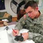 Ben Boettger/Peninsula Clarion Private Sam Cottrell of the National Guard's 297th Cavalry Brigade inventories a rifle scope - equipment that will be redistributed as the cavalry unit becomes infantry - at Kenai's National Guard Armory on Wednesday, August 12.