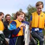 Ben Boettger/Peninsula Clarion From left to right: Olivia Loehr, guide Drew Anderson,  (with a silver salmon he caught) and Scott Loehr exit a boat during the Take Our Kids Fishing event at Soldotna's Centenial Park on Thursday, August 13.
