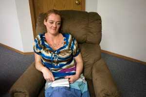 Photo by Rashah McChesney/Peninsula Clarion  Aubrey Austin curls up with a book in an armchair at the LeeShore Center where she has been staying for two months on August 13, 2015 in Kenai, Alaska. The center is in its 30th year of operating. At present, all 32 of its beds are filled.