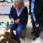Photo by Kelly Sullivan/ Peninsula Clarion Fireweed Fiber Guild members Lee Choray-Ludden shows Mario Reyna how to spin fibers on a spinning wheel, Friday, August 15, at the Kenai Peninsula Fair in Ninilchik, Alaska.