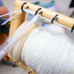Photo by Kelly Sullivan/ Peninsula Clarion Fireweed Fiber Guild members Jane Conway spins a bobbin full of white wool Friday, August 15, at the Kenai Peninsula Fair in Ninilchik, Alaska.
