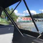 Photo by Rashah McChesney/Peninsula Clarion Dwight Kramer, member of the Kenai Area Fisherman's Coalition, watches revelers at a party during the Kenai River Sportfishing Association's annual Kenai River Classic as he floats down the Kenai River with a banner protesting the event and its founder, Bob Penney, on Wednesday August 19, 2015 in Soldotna, Alaska.