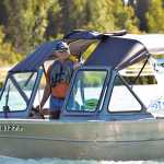 Photo by Rashah McChesney/Peninsula Clarion  A protestor pulls his boat away from the Swiftwater Campground before heading to protest in front of a Kenai River Sportfishing Association event at founder Bob Penney's riverfront house on Wednesday August 19, 2015 in Soldotna, Alaska.