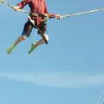 Ben Boettger/Peninsula Clarion Grayden Musgrave reaches the peak of his bounce on a bungee trampoline at the Ninilchik Fair Ground during the Kenai Peninsula State Fair on Friday, August 22.