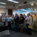 Photo by Megan Pacer/Peninsula Clarion Veterans and Veterans Affairs employees recite the Pledge of Allegiance before a VA listening session targeted at the Veterans Choice Act held Monday, Aug. 24 2015, at the Kenai Chamber of Commerce and Visitors Center in Kenai, Alaska.