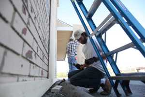Photo by Kelly Sullivan/ Peninsula Clarion Andy Schaafsma, co-owner of Odie's Deli puts panels up on the outside of the building, Aug. 27, 2015, in Soldotna, Alaska.