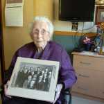 Photo by Megan Pacer/Peninsula Clarion Fern Elam, who turned 105 on Friday, holds a picture of herself with her 13 siblings while relaxing in her room on Tuesday, Sept. 1 2015, at Heritage Place in Soldotna, Alaska.
