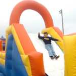 Photo by Megan Pacer/Peninsula Clarion Volunteer Amy West hands a hamburger to 4-year-old Brody Merchant, of Kenai, on Monday, Sept. 7, 2015 at the Labor Day Picnic at Kenai Central High School in Kenai, Alaska.