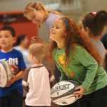 Ben Boettger/Peninsula Clarion Students hold rugby balls as members of the U.S Women's Rugby Sevens Olympic team prepare to lead them in a tag-like game during a presentation on Wednesday, September 9 in the gymnasium of Mountain View Elementary School.