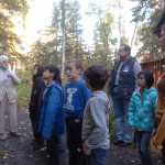 Photo by Megan Pacer/Peninsula Clarion Soldotna's first female homesteader Marge Mullen, left, guides third and fourth grade Soldotna Elementary students on a tour through relocated cabins on Thursday, Sept. 10, 2015 at the Soldotna Homestead Museum in Soldotna, Alaska.