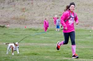 Photo by Megan Pacer/Peninsula Clarion A runner and her dog cross the finish line at the Making Strides Against Breast Cancer Walk/Run on Sunday, Sept. 13, 2015 at the Tsalteshi Trails in Soldotna, Alaska.