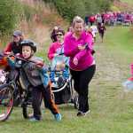 Photo by Megan Pacer/Peninsula Clarion Runners, walkers, parents and children charge up the first hill at the start of the Making Strides Against Breast Cancer Walk/Run on Sunday, Sept. 13, 2015 at the Tsalteshi Trails in Soldtona, Alaska.