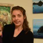 Julie Tomich holds her daughter, Xelia, at her show's First Friday opening. (Photo by Michael Armstrong/Homer News)