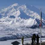People stand at the Eielson Visitor Center with a view of North America's tallest peak, Denali, in the background, Wednesday, Sept. 2, 2015, in Denali National Park and Preserve, Alaska. The park covers more than 6 million acres, about the size of Vermont, and is an adventurer's paradise with few marked trails, inviting backcountry exploration. (AP Photo/Becky Bohrer)
