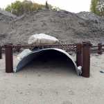 Photo by Rashah McChesney/Peninsula Clarion  Private residents on properties along Kalifornsky Beach Road have constructed their own drainage solutions to deal with high water in the area including this one that belongs to a property owner who constructed a pipe to divert water pouring in from a large storm drain on the east side of the road under his property on the west side of the road and onto the beach bordering the Cook Inlet.