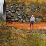 Photo by Rashah McChesney/Peninsula Clarion  Kenai Peninsula Borough resident Dan Sterchi stands in a drainage ditch that was built near a portion of Kalifornsky Beach Road that has collapsed and washed into the Cook Inlet twice on Sept. 4, 2015 near Kenai, Alaska. Sterchi's nearby home borders a parcel that the borough is considering trading to a private property owner minus an easement which he says will not be large enough to allow for adequate drainage of floodwater in the area.