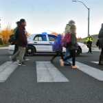 Jane Fellman (right), coordinator of the Safe Kids of the Kenai Peninsula Coalition, hands out string backpacks at the annual walk to school event.