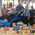 From left, Stanley Ford Salesman Dave Bartelmay, Sales Manager Joe Wink, Kenai Peninsula School District Assistant Superintendent John O'Brien, and Stanley Ford credit doctor/sales Paul Olson, pose with a Ford Focus filled with school supplies to be donated to the school district. According to Olson, last year, the dealership in Kenai collected $7,000 worth of school supplies and winter clothes for the school district to help children in need. This year, Stanley Ford collected $8,500 worth of donations, and Olson is hoping to reach $10,000 next year.