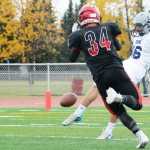 Ben Boettger/Peninsula Clarion Soldotna High School football player Tommy Flores kicks the ball past Kenai's Draiden McMinn during a game on Saturday Oct. 3 at Kenai Central High School.