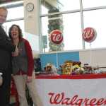 A Walgreens regional manager congratulates Soldotna Store Manager Traci Riddle at the grand opening give-a-way table.