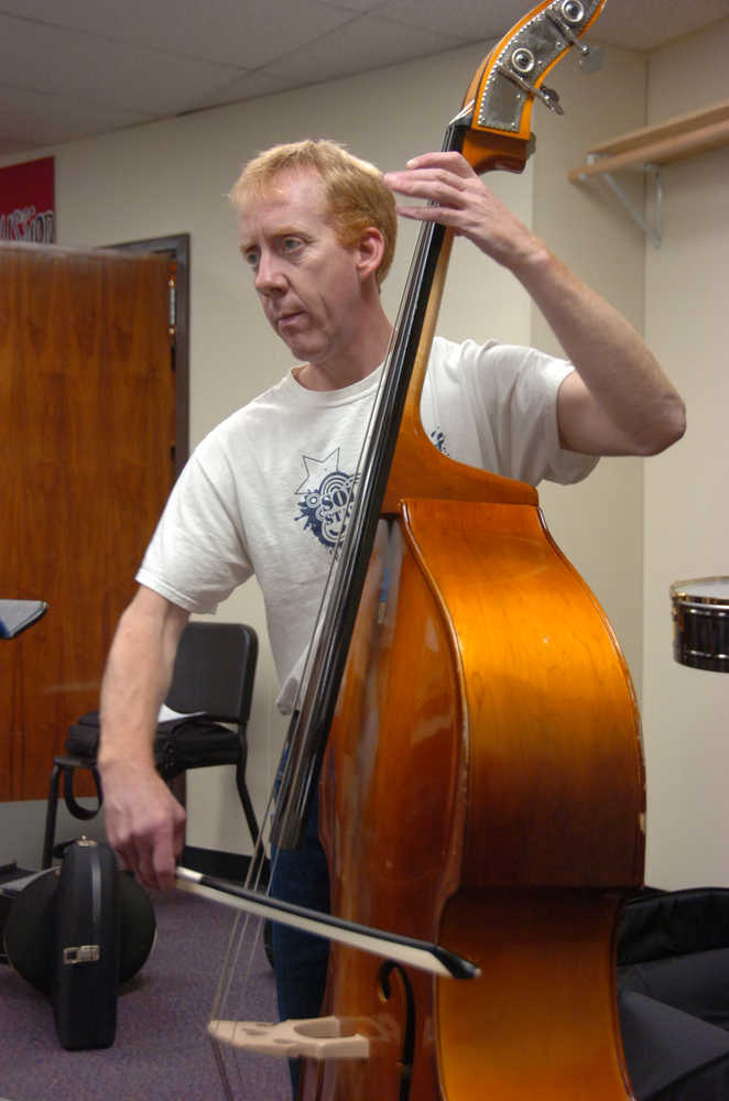 Photo by Megan Pacer/Peninsula Clarion Kent Peterson plays the string bass during a Kenai Peninsula Orchestra practice on Thursday, Oct. 1, 2015 at Kenai Central High School.