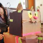 Ben Boettger/Peninsula Clarion Jessica Franklin attachs tape to a cardboard cat she built at the Cardboard Challenge on Friday Oct. 9 at the Soldotna Public Library.
