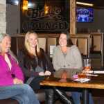 Owner Michelle Dix visits with friends by the new fireplace at the Bridge Lounge.