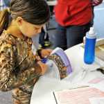 Abigail Price prepares a photo for her geography project on Canada Friday at the IDEA homeschool group's geography club meeting.