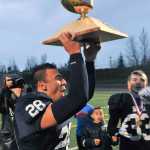 Drew Gibbs brings the trophy to his teammmates.  Photo for the Clarion by Michael Dinneen